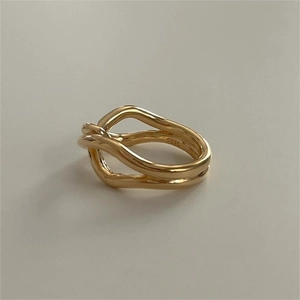 Macro detail of 925 sterling silver knotted ring with polished gold finish and S925 stamp