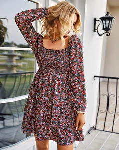 Détail d'une robe courte fleurie à col carré avec buste smocké et volants superposés