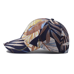 Dark blue cotton baseball cap with tropical leaf print and curved brim in side view