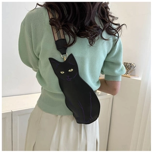 Detail of cute black cat-shaped crossbody bag with wide striped fabric shoulder strap