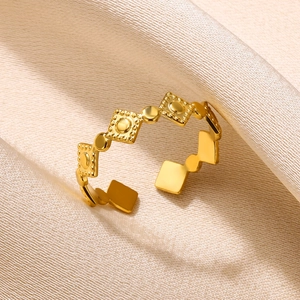 Detail of golden geometric ring with embossed textures on elegant silk background