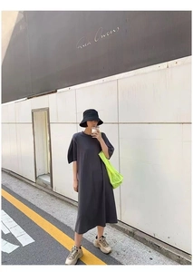 Detail of grey midi dress paired with fluorescent green mesh tote and black bucket hat