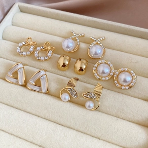 Detail of six-pair gold earring set with pearls and rhinestones in a velvet box