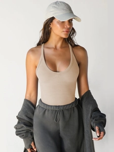 Dettaglio del canotta yoga a costine beige con scollo a U indossata da una modella