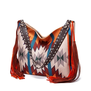 Detail of bohemian tote bag featuring colorful geometric jacquard and long side tassels