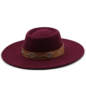 Burgundy wool fedora hat with wide brim featuring a brown studded leather band decoration