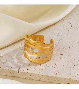 Détail de la bague dorée irrégulière à couches ondulées avec texture martelée sur pierre