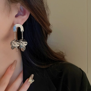 Macro detail of silver U-shaped dangle earrings with hammered metal sequins and a glossy finish