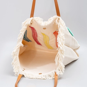 Borsa tote beige in tela intrecciata con ricami colorati, dettagli frangiati e manici marroni