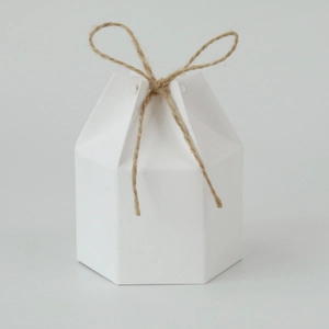 Close-up of white hexagonal paper gift box with a brown jute twine ribbon bow