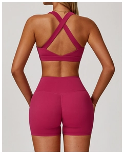 Back view of a berry red high-waist yoga shorts set with cross-back sports bra design