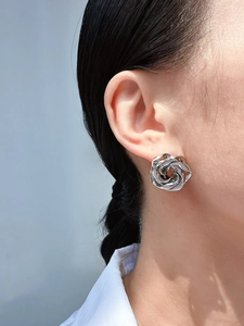 Macro shot of silver spiral twist earrings showing metallic texture and artistic design