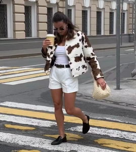 Détail d'une veste courte à imprimé vache style français avec boutons et petit col carré