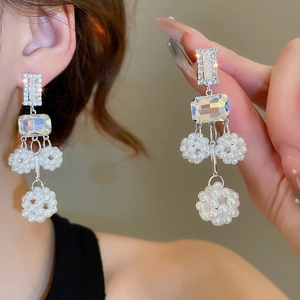 Detail shot of long tassel earrings with pearlescent beads and iridescent crystals