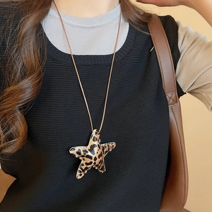 Close-up of leopard print star pendant necklace with refined stitching and brown cord