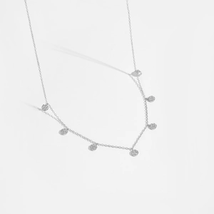 Detail of silver S925 necklace with seven sparkling round zircon pendants on white background