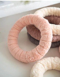 Close-up of plush thickened headbands in pink, white, brown and grey soft faux fur texture
