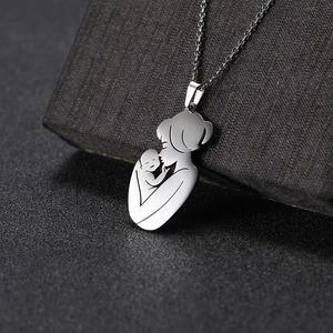 Macro shot of silver mother and baby silhouette pendant on black gift box
