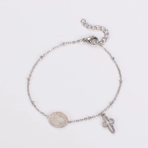 Macro detail of silver stainless steel bracelet with St. Benedict medal and hollow cross