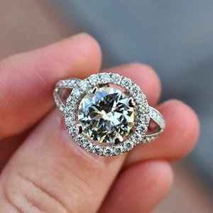 Classic silver halo engagement ring with round cubic zirconia on a female finger