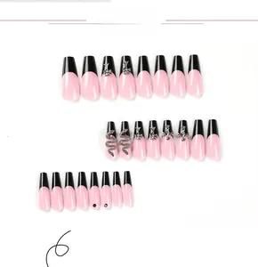 Détails de faux ongles longs avec pointes françaises noires, serpents et croix argentées