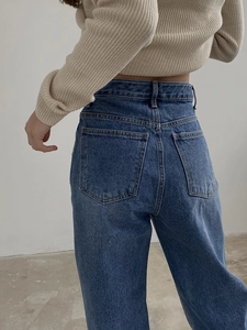 Detailed back view of high-waist patchwork jeans with rear pockets and denim texture