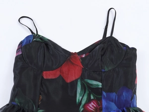 Détail d'une robe en organza à fleurs rouges et bleues avec de fines bretelles