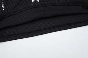 Détail macro du tricot côtelé noir avec strass brillants et coutures de précision soignées