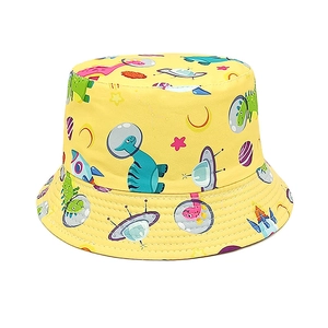 Detail of yellow kids bucket hat featuring cartoon astronaut dinosaur and UFO prints