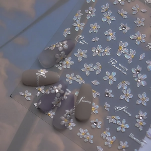 Detail of 3D embossed white pearlescent flower nail stickers with rhinestones