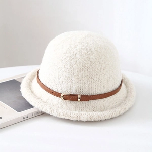 Gros plan du chapeau bob en polaire blanche avec sangle en cuir brun et texture douce