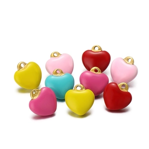 Macro shot of colorful enamel heart charms with gold loops in various vibrant shades