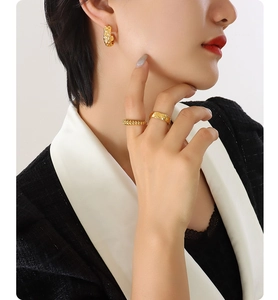 Macro view of C-shaped earrings and quilted pattern ring in 18K gold plated titanium steel