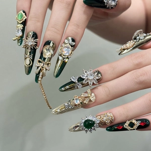 Unghie finte di lusso color smeraldo con strass, perle e nappine dorate lucide