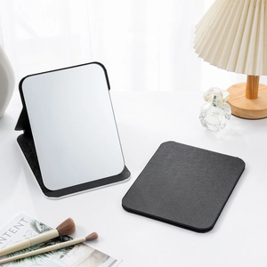Detail of portable black PU leather makeup mirror shown in open and folded positions