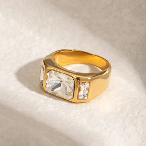 Detail of wide gold stainless steel ring featuring a large rectangular cut zircon center stone