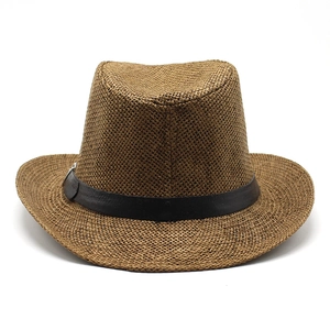 Close-up of woven straw texture and black leather band on brown fedora cowboy hat