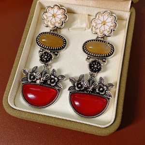 Detail of vintage bohemian floral drop earrings with colorful stones in a luxury box