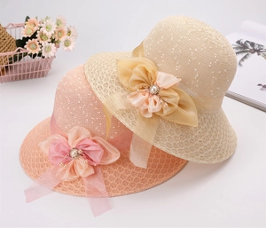 Dettaglio di cappelli di paglia estivi con grandi fiocchi in chiffon e accenti di perle