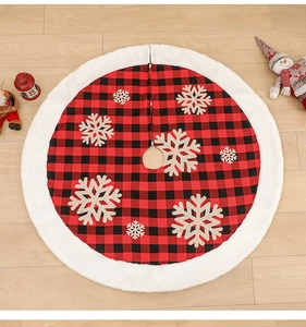 Detail of red and black buffalo plaid Christmas tree skirt with white plush trim and snowflakes