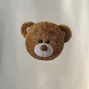 Detail of a 3D plush brown bear stitched onto a high-quality cream canvas tote bag