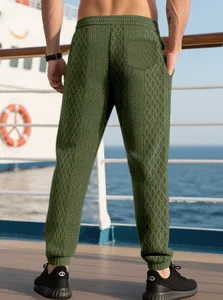 Detail of men waffle knit joggers in olive green with textured geometric pattern