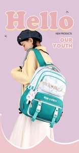 Green and white patchwork backpack with a cat plush pendant worn by a model in lifestyle view