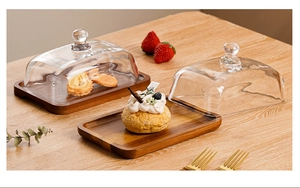 Detail of rectangular acacia wood butter dish with a clear glass dome lid for desserts