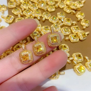 Detailed close-up of 18k gold plated square yellow diamond pendant with zircon halo