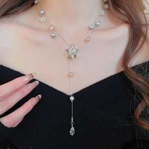 Detail of double-layer star necklace with pearl tassels and crystal drop on model