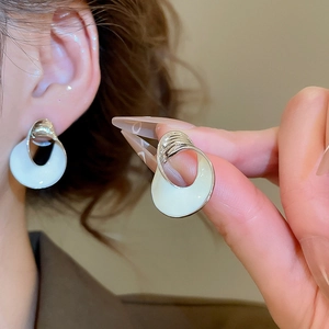 Detailaufnahme der geometrischen Silber-Ohrringe mit minimalistischer cremefarbener Emaille