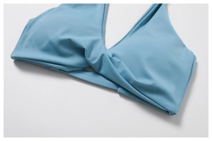Detail of smog blue yoga top featuring a stylish front twist knot design and smooth fabric