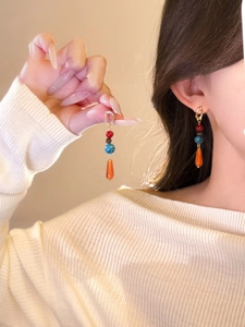 Vue détaillée des boucles d'oreilles perlées colorées avec pendentif goutte d'agate