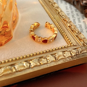 Macro shot of vintage gold heart ring with red enamel and sparkling cubic zirconia